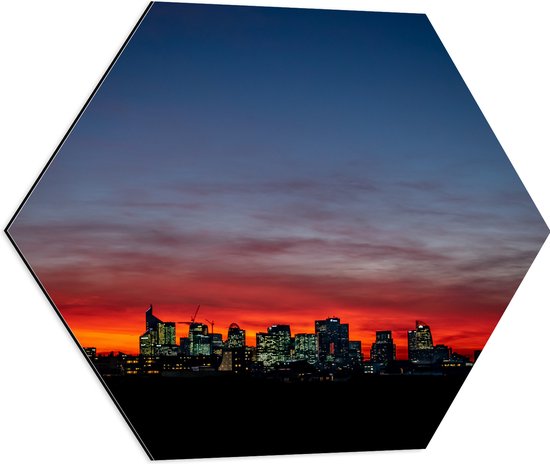 Dibond Hexagon - Zonsondergang achter Gebouwen met Verlichting - 60x52.2 cm Foto op Hexagon (Met Ophangsysteem)