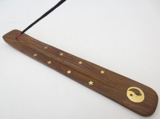 Donker houten wierookplank met gouden sterren en Yin Yang symbool aan het uiteinde.