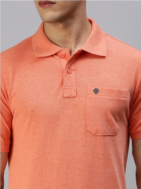 Détail d'un polo orange avec boutons, poche poitrine et logo brodé.