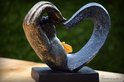 Zwarte hartvormige urn met gouden handen, met een amberkleurige glazen ster.