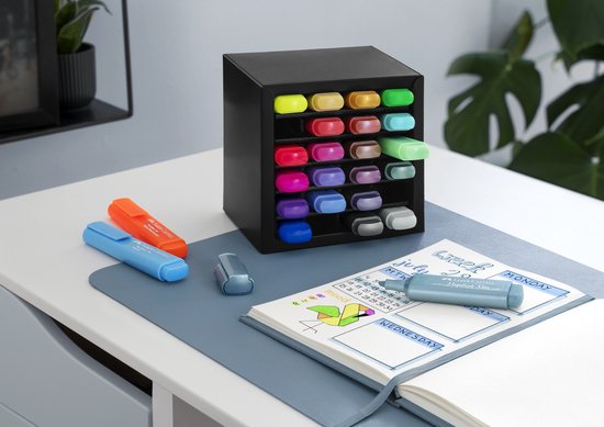 Bureau met een zwarte Textliner deskset, oranje en blauwe Textliners en een notitieboekje met weekplanning.