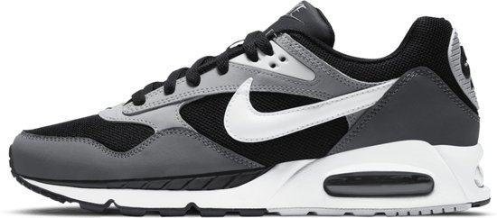Linker zijkant van een zwarte Nike sneaker met grijze panelen en een witte Nike 'swoosh'. Zichtbare 'Air'-unit in de witte zool.
