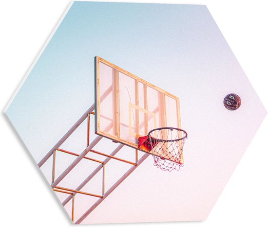 PVC Schuimplaat Hexagon - Bal Vallend in Basket onder Blauwe Lucht - 40x34.8 cm Foto op Hexagon (Met Ophangsysteem)