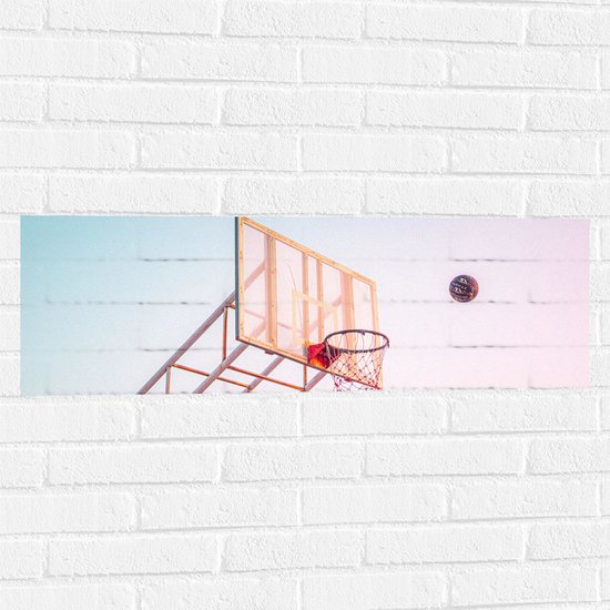 Muursticker - Bal Vallend in Basket onder Blauwe Lucht - 90x30 cm Foto op Muursticker