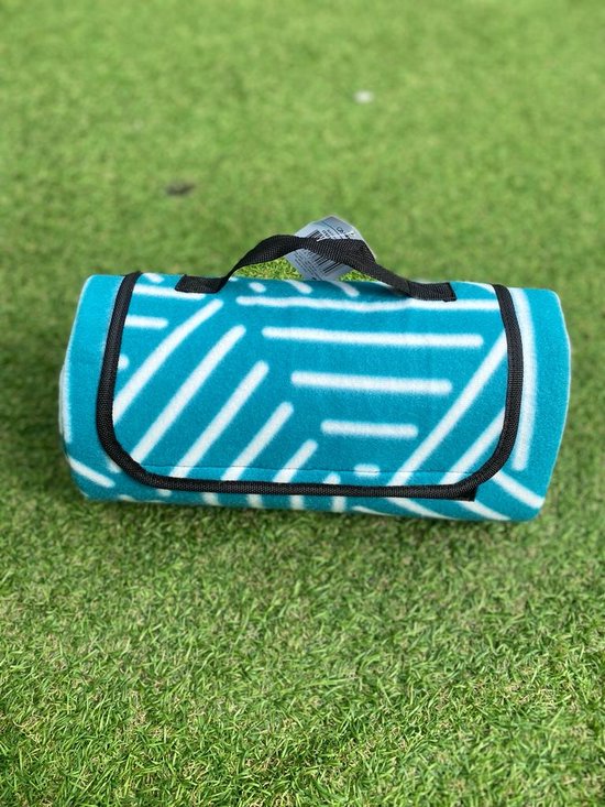 Couverture de pique-nique turquoise roulée avec motif géométrique blanc et poignée.