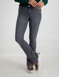 Model in grijze flared jeans en sneakers.