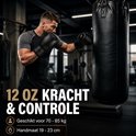 Man traint met zwarte 12 oz bokshandschoenen op een bokszak. Geschikt voor 70-85 kg.