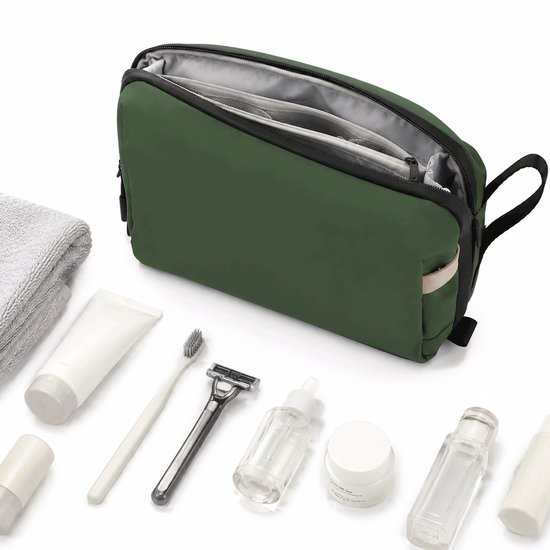 Trousse de toilette verte à fermeture éclair ouverte, à côté d'une serviette et de produits de soins : dentifrice, brosse à dents, rasoir, crèmes et parfums.