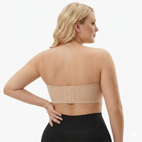 Model met blote schouders, van achteren gezien, draagt een huidkleurige strapless bh met een 3-haaks sluiting.