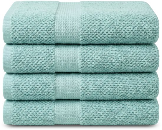 Quatre serviettes vert menthe empilées, avec un motif tissé rayé.