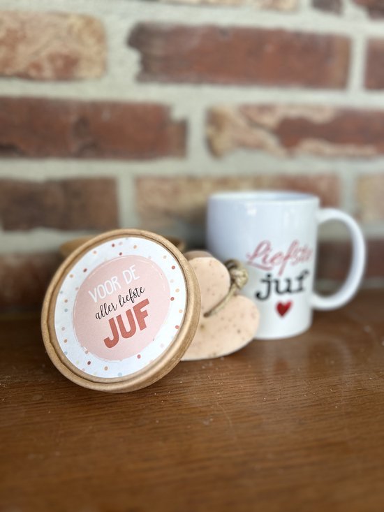 Ronde doos met de tekst "Voor de aller liefste juf" in roze en stippen, naast een mok en hartvormige zeep.