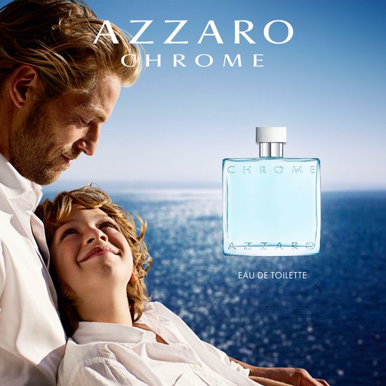 Vader en zoon kijken naar Azzaro Chrome Eau de Toilette fles met oceaan op achtergrond.