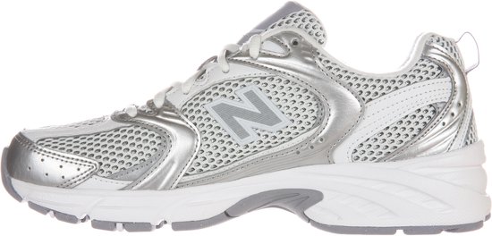 Zilverkleurige New Balance sneaker, zijaanzicht. Wit mesh en zilveren overlays. Model 530.