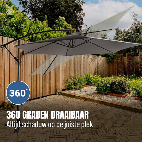 Grijze zweefparasol die 360 graden draaibaar is, staat op een terras met houten schutting.