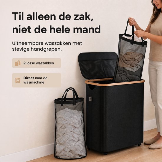 Een vrouw met een beige trui en broek haalt een zwarte, gaasachtige waszak met stevige handgrepen uit een zwarte wasmand met bamboehouten frame.
