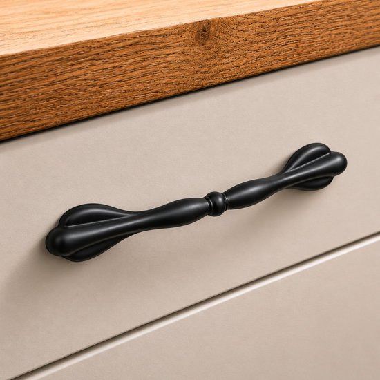 Zwarte meubelgreep op een lichte, beige lade met houten bovenblad.