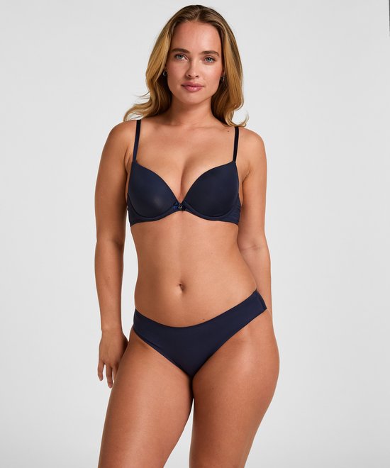 Model draagt een marineblauwe Plunge beugel bh en bijpassende slip.