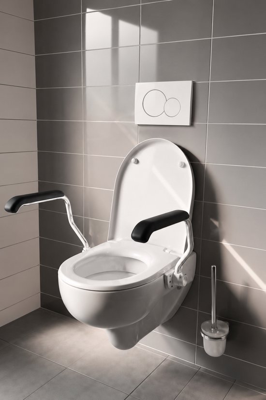 Witte toiletpot met opklapbare, zwart-gecoate armsteunen, gemonteerd op een grijs betegelde muur.
