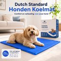 Kleine, lichtgekleurde hond rustend op blauwe koelmat in woonkamer. Tekst: Hondenkoelmat.