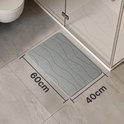 Tapis de bain gris de 60x40cm à motif ondulé, à côté d'une cabine de douche.
