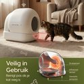 Een kat loopt naar een witte automatische kattenbak, sensoren zijn zichtbaar.