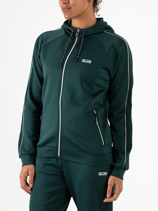 Model in donkergroene trainingsset: hoodie met rits, capuchon, witte bies en broek.