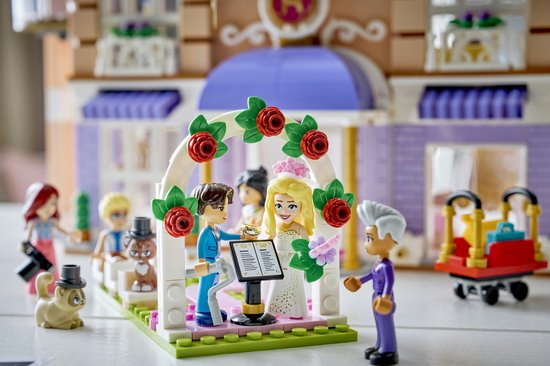 LEGO Friends bruiloftsscène met bruid, bruidegom, gasten, kat en bloemenboog.
