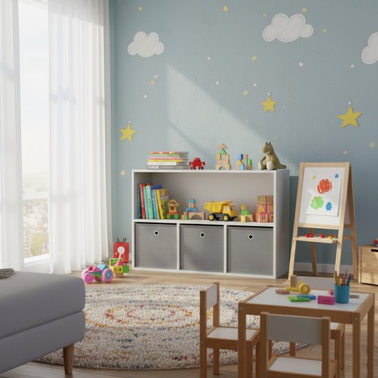 Witte kast met drie grijze opbergdozen in een kinderkamer met speelgoed.