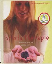 Vrouw met lange blonde haren, houdt donkere kristallen in haar handen. Titel: Kristaltherapie.