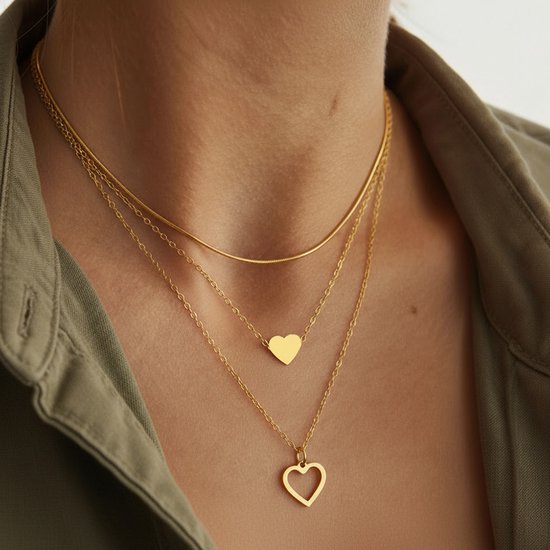 Gouden ketting met drie lagen. Bovenste slangenketting, middelste ketting met een massief hartje, onderste ketting met een opengewerkt hartje.