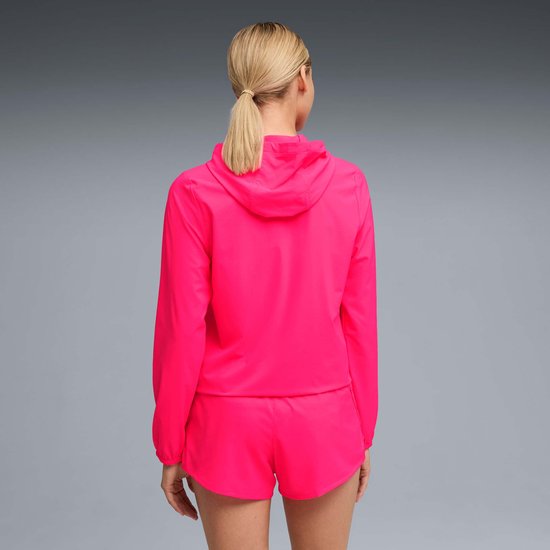Vrouw, achterkant, felroze jas met capuchon en bijpassend korte broek.