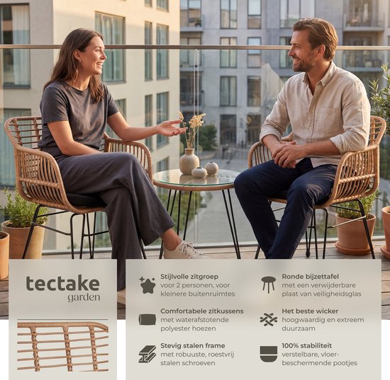 Koppel op een balkon, zittend op bruine rotan stoelen met zwarte kussens, bij een glazen tafel. Met productinformatie.