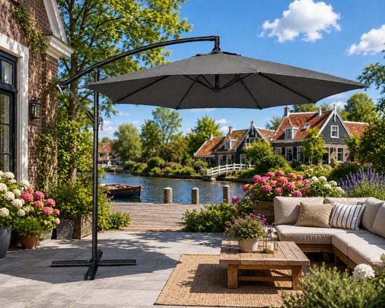 Grijze zweefparasol met stalen frame, kruisvoet, loungeset en bloempotten.