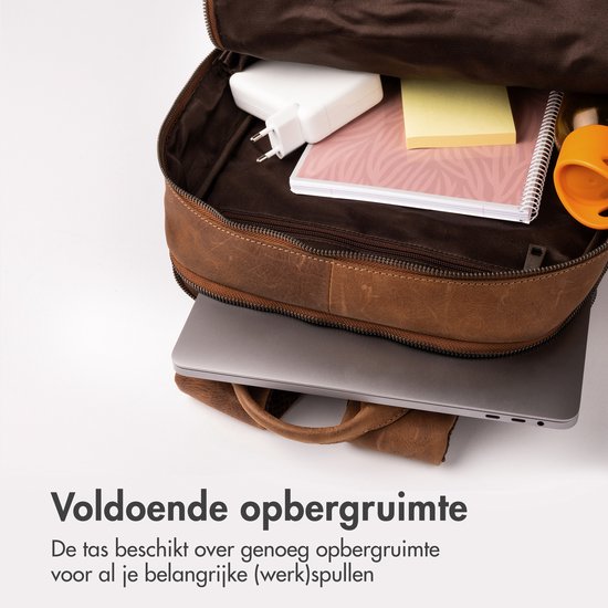Binnenkant van de bruine leren rugzak, gevuld met diverse spullen.