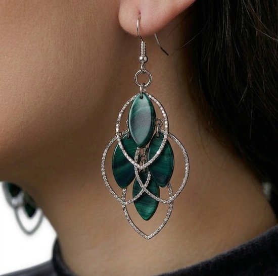 Pendants d'oreilles argentés à feuilles vert foncé, en détail.