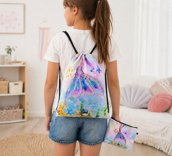 Meisje met een sporttas en etui met zeemeerminnenprint op de rug. De tas is versierd met een zeemeerminnenstaart, zeedieren en gouden glitter.