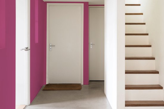 Een hal met fuchsia muur, witte deuren en houten trap.