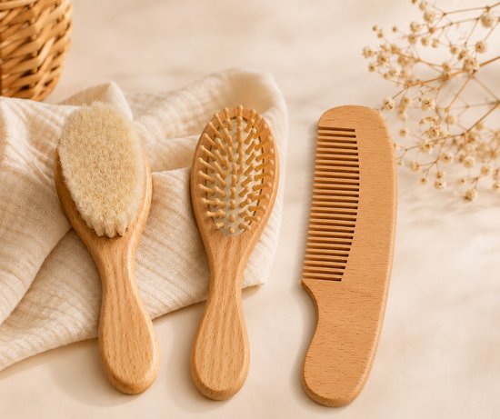 Drie houten babyverzorgingsproducten, waaronder een borstel met zachte haren, een borstel met pinnetjes en een kam.