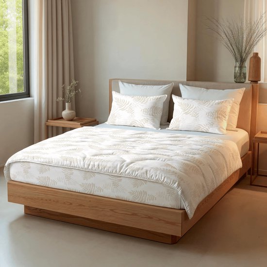 Een opgemaakt bed met een wit dekbed en kussens met beige bladmotieven, bij een raam en houten nachtkastjes.