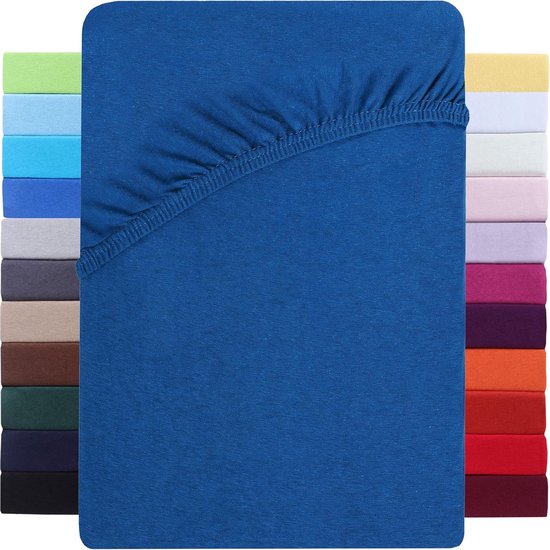 Blauw hoeslaken naast stapels hoeslakens in diverse kleuren.
