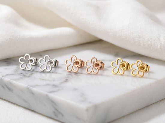 Drie paar bloemvormige oorknopjes in zilver, rosegoud en goud.