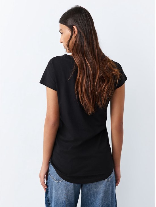 Model draagt een zwart T-shirt met V-hals en korte mouwen, achterkant.