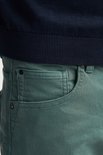 Detail van de zakken en leren label van een groene slim fit stretch denim shorts.