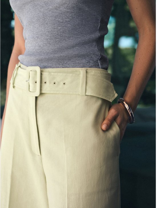 Detail van de lichtgroene culotte met riem en gesp.