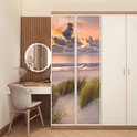 Zelfklevende deurposter met een zonsondergang boven zee, strand en duingras.