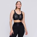 Model draagt een zwarte sportbeha met geometrisch patroon en zwarte sportbroek.