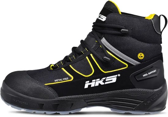 Zwarte werkschoen met gele accenten, veters, 'HKS' logo en reflecterende bies. 'Metal Free' en 'Heel Support'.