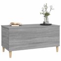 Grijze salontafel met houtnerf, gesloten, met boek en bloemen, op houten pootjes.