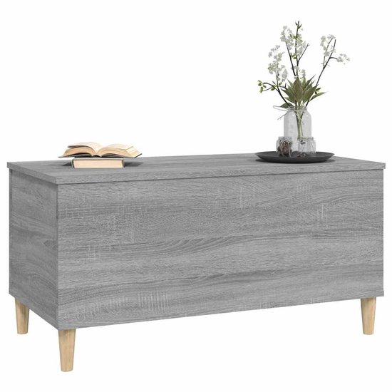 Grijze salontafel met houtnerf, gesloten, met boek en bloemen, op houten pootjes.