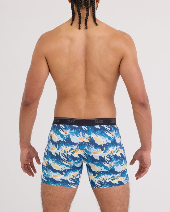 Achterkant man met SAXX boxershort met blauwe, gele en oranje visprint. "SAXX" op de tailleband.